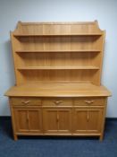 An Ercol elm dresser with cupboards and drawers beneath