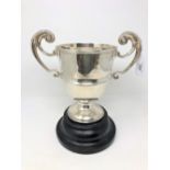 An Edwardian silver twin-handled trophy cup, Chester 1902, height 22cm, on turned ebonised plinth.