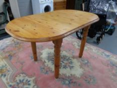 An oval pine extending kitchen table with a leaf