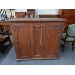 A 20th century carved double door cabinet on bun feet