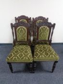 A set of four carved Edwardian dining chairs in green fabric