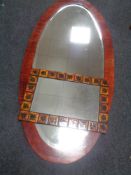 A large oval framed bevelled mirror together with a Danish tiled mirror