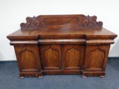 A Victorian mahogany inverted breakfronted sideboard on bun feet