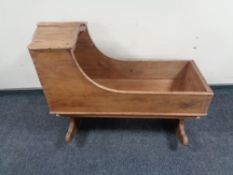 An antique pitch pine rocking cot