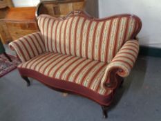 An antique mahogany framed scroll arm settee