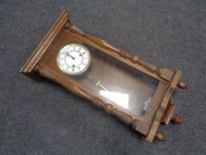 A 20th century oak cased Hermle wall clock with brass and enamelled dial,