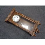 A 20th century oak cased Hermle wall clock with brass and enamelled dial,