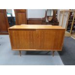 A mid 20th century beech sliding door sideboard 46 cm x 137.5 cm x 87 cm.