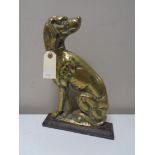 An antique brass and cast iron door stop in the form of a dog.