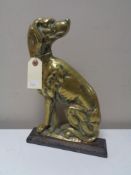 An antique brass and cast iron door stop in the form of a dog.