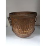 An antique copper twin handled cooking pot