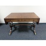 An antique mahogany Regency style two drawer flap sided table
