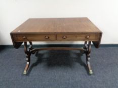 An antique mahogany Regency style two drawer flap sided table