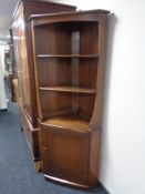 An Ercol elm corner cabinet fitted with shelves