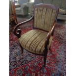 An antique mahogany scroll armchair