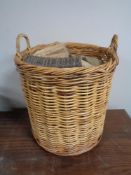 A large wicker log basket containing logs.