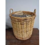 A large wicker log basket containing logs.