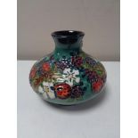 A Moorcroft baluster vase, depicting summer fruit on an emerald green ground, height 10.5 cm.