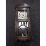 A 20th century oak eight day wall clock with pendulum and key