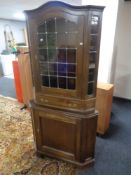 A reproduction oak corner cabinet