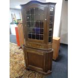 A reproduction oak corner cabinet