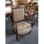 An antique mahogany scroll arm armchair