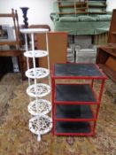 A cast metal six tier pan stand together with a red metal framed shelf