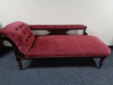 An antique chaise longue in maroon dralon