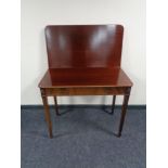 A Victorian mahogany turnover top table on tapered legs