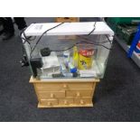 A fish tank with accessories on small pine six drawer chest