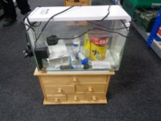 A fish tank with accessories on small pine six drawer chest