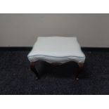 An antique mahogany footstool on cabriole legs