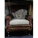 An antique horse hair filled armchair in floral fabric and a green loose cover