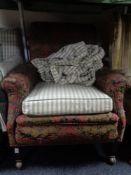 An antique horse hair filled armchair in floral fabric and a green loose cover