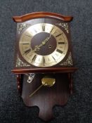 A 20th century wall clock with pendulum and key