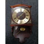 A 20th century wall clock with pendulum and key