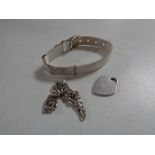 A silver watch strap together with a silver bracelet and heart pendant