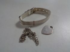 A silver watch strap together with a silver bracelet and heart pendant