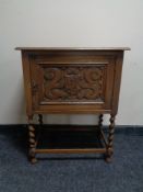 An oak 20th century single door cabinet on barley twist legs