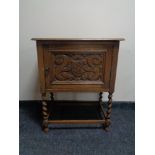 An oak 20th century single door cabinet on barley twist legs