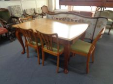 A mid 20th century beech dining table and six rail back chairs