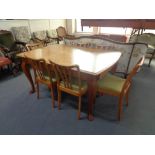 A mid 20th century beech dining table and six rail back chairs