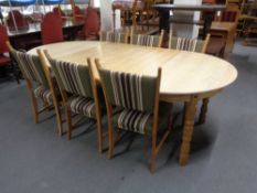 A circular blond oak extending dining table with two leaves together with a set of six chairs