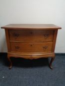 An early 20th century two drawer chest on cabriole legs