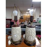 A pair of cream pottery table lamps on wooden bases