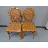 A pair of bamboo and wicker dining chairs