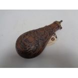 A reproduction brass and copper embossed black powder flask CONDITION REPORT: