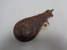 A reproduction brass and copper embossed black powder flask CONDITION REPORT: