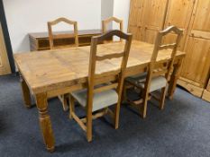 A pine farmhouse kitchen table (missing a drawer) and four pine rail back chairs