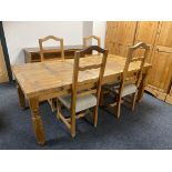 A pine farmhouse kitchen table (missing a drawer) and four pine rail back chairs